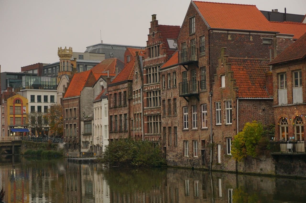 Ghent waterfront — historic buildings along the canal, reflecting the layered governance structures of Belgian cities