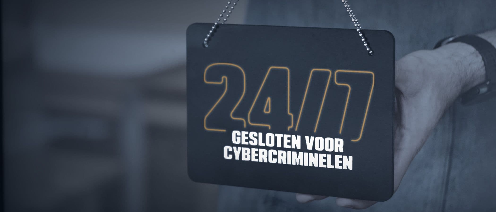 Hand holding a 24/7 "Gesloten voor cybercriminelen" sign on a glass door (CCB campaign)